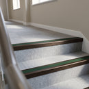Dark bronze aluminium stair nosing with Dark Green insert fitted to pale grey carpet tile on an office corridor stair