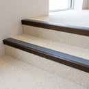 Dark bronze aluminium stair nosing with Dark Grey insert fitted to pale cream carpet tile on a civic building stair