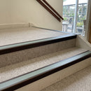 Dark bronze aluminium stair nosing with Sage Green insert fitted to pale oatmeal carpet on a garden centre stair