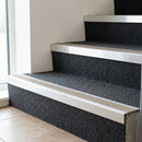 Mill finish aluminium stair nosing with Beige insert fitted to dark charcoal carpet tile on an office block stair