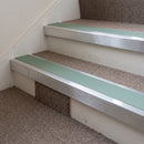 Mill finish aluminium stair nosing with Sage Green insert fitted to taupe carpet on a village hall stair
