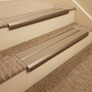 Dark bronze aluminium bullnose stair nosing with twin beige inserts fitted on a hotel corridor step