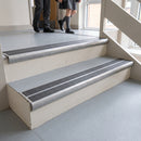 Mill finish aluminium bullnose stair nosing with twin premium black inserts fitted on a school stairwell step