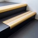 Satin gold aluminium bullnose stair nosing with twin sahara inserts fitted on a building foyer step
