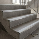 Slimline aluminium stair nosings with ice grey anti-slip inserts on grey tiled staircase