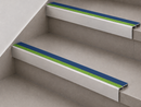 Blue and green slimline insert stair nosings fitted to two pale stone-effect steps