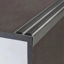 Close-up of inox brushed-effect 36x20mm aluminium stair nosing with two black anti-slip rubber inserts on a step edge