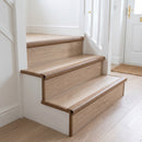 Oak wood-effect push-in laminate stair nosing fitted along the front edge of each step on a domestic staircase