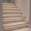 Tiled staircase with LED stair nosings fitted with grey diffusers for a softer, subdued glow on the risers