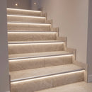Tiled staircase with silver LED stair nosings fitted with white diffusers, giving a smooth even line of light on each riser