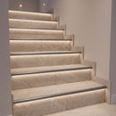 Tiled staircase with titanium grey aluminium LED stair nosings flush with the treads and LED light on the risers