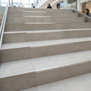 Bare aluminium stair nosing channel only on tiled commercial staircase no insert