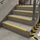 Heavy duty aluminium stair nosing with yellow DDA anti-slip insert on industrial warehouse staircase UK