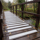 Light grey 90mm fine grit GRP anti-slip decking strips across a timber park footbridge