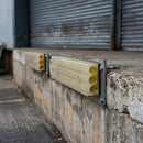 Yellow polyurethane loading dock buffers bolted along the concrete edge of a warehouse loading dock