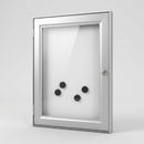 Closed lockable noticeboard with a satin silver anodised aluminium frame, clear acrylic door, silver key barrel lock and a white magnetic back panel holding four black button magnets, on a plain light grey studio background