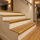 Gold anodised aluminium LVT stair nosing on honey oak vinyl hotel stairs