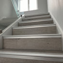Silver anodised aluminium LVT stair nosing on a grey oak click vinyl staircase with glass balustrade