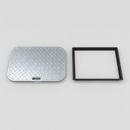 Studio product photo of a rectangular galvanised steel manhole cover next to its black polypropylene frame, showing the diamond-tread top surface and recessed lift handle slot