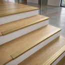 Matt brass self-adhesive aluminium stair nosing 30mm x 20mm fitted along the full width of oak laminate stairs