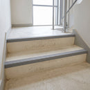 Mid grey GRP anti-slip stair nosings fitted to the front edge of concrete steps in a stairwell