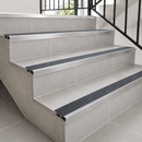 Slimline aluminium stair nosings with mid grey anti-slip inserts on pale tiled steps
