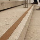 Brown 8mm non-slip stair tread insert set into a concrete step