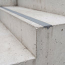 Grey dovetail non-slip stair tread insert set into a concrete step