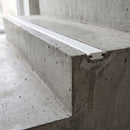 White dovetail non-slip stair tread insert set into a concrete step