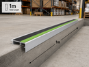 1 metre aluminium stair nosing with black and green anti-slip inserts on a concrete step edge in a warehouse, length marked
