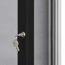 Close up of the chrome cam lock and key on the black 45mm anodised aluminium door profile of an outdoor notice board, showing the polycarbonate cover, black rubber weather seal and grey felt panel