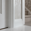 White satinwood paint freshly applied to skirting boards and a door frame in a UK home interior, smooth low-sheen finish