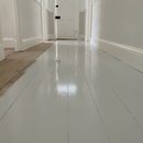 Grey wood floor paint freshly applied to timber floorboards in a UK workshop, durable hard-wearing finish