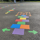 Blue and yellow playground paint freshly applied to a school playground games marking area in the UK