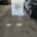 Clear polyurethane sealer applied to a bare grey concrete garage floor, enhancing the natural concrete colour