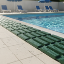 Green anti-slip wet area matting laid poolside at an outdoor swimming pool on a sunny day