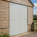 Light grey painted timber barn door and cladding on a UK farm building freshly coated with barn and shed paint
