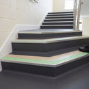Photoluminescent aluminium stair nosing 56x55mm with beige PVC insert fitted to a school stairway, green glow strip along the nose