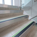 Photoluminescent aluminium stair nosing 56x55mm with black PVC insert fitted to a concrete office stair, green glow strip along the nose
