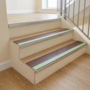 Photoluminescent aluminium stair nosing 56x55mm with brown PVC insert fitted to a timber-floored stair, green glow strip along the nose