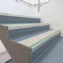Photoluminescent aluminium stair nosing 56x55mm with canvas PVC insert fitted to a hospital stairway, green glow strip along the nose