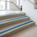 Photoluminescent aluminium stair nosing 56x55mm with cobalt blue PVC insert fitted to a library stair, green glow strip along the nose