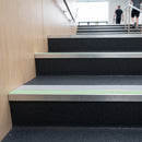 Photoluminescent aluminium stair nosing 56x55mm with ice grey PVC insert fitted to a leisure centre stair, green glow strip along the nose