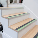 Photoluminescent aluminium stair nosing 56x55mm with midnight grey PVC insert fitted to a timber stair, green glow strip along the nose