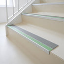 72x55mm aluminium stair nosing with a Dolphin Grey PVC insert and green photoluminescent strip fitted to a communal interior stair