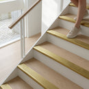 Polished brass 89mm bull nose stair nosings on oak stairs as a person walks down