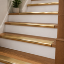 Polished brass 89mm bull nose stair nosings on oak treads with white risers