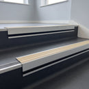 Porth Stone Castellated insert in a cut to size 66x55mm aluminium stair nosing with 13mm black riser highlight, fitted to interior steps