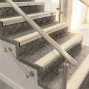 Raked back nosings with smooth Portland stone inserts on mottled stone steps between stainless handrails