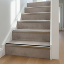 Aluminium anti-slip stair nosing in Anodised Champagne with Black Insert installed on carpeted stairs